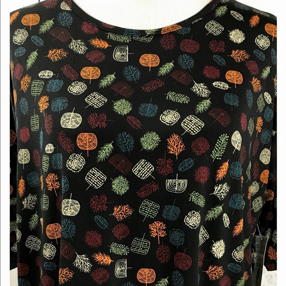 LuLaRoe S Irma Tunic Top, half sleeve, black background with colorful foliage.